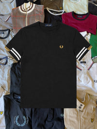 Schwarzes Just Casual Fred Perry Baumwoll-T-Shirt mit goldenem Lorbeerkranz-Logo und gestreiften Ärmelbündchen