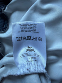 Just Casual Lonsdale Trainingsjacke Pflegeetikett mit Waschanleitung und Markenlogo auf weißem Stoff